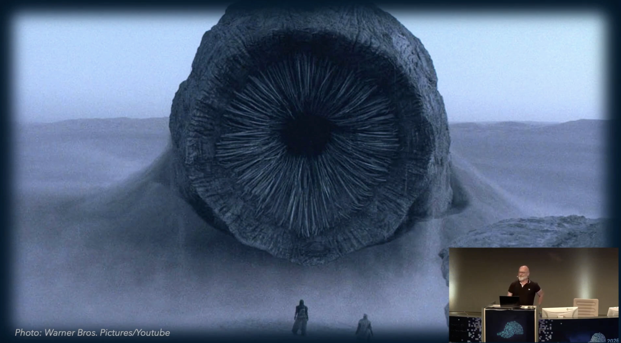 A still image from the keynote recording, showing the giant desert
sandworms from Frank Herbert's Dune universe, known as Shai Hulud, which is
also the name given to a recent and notorious software supply chain malware
worm